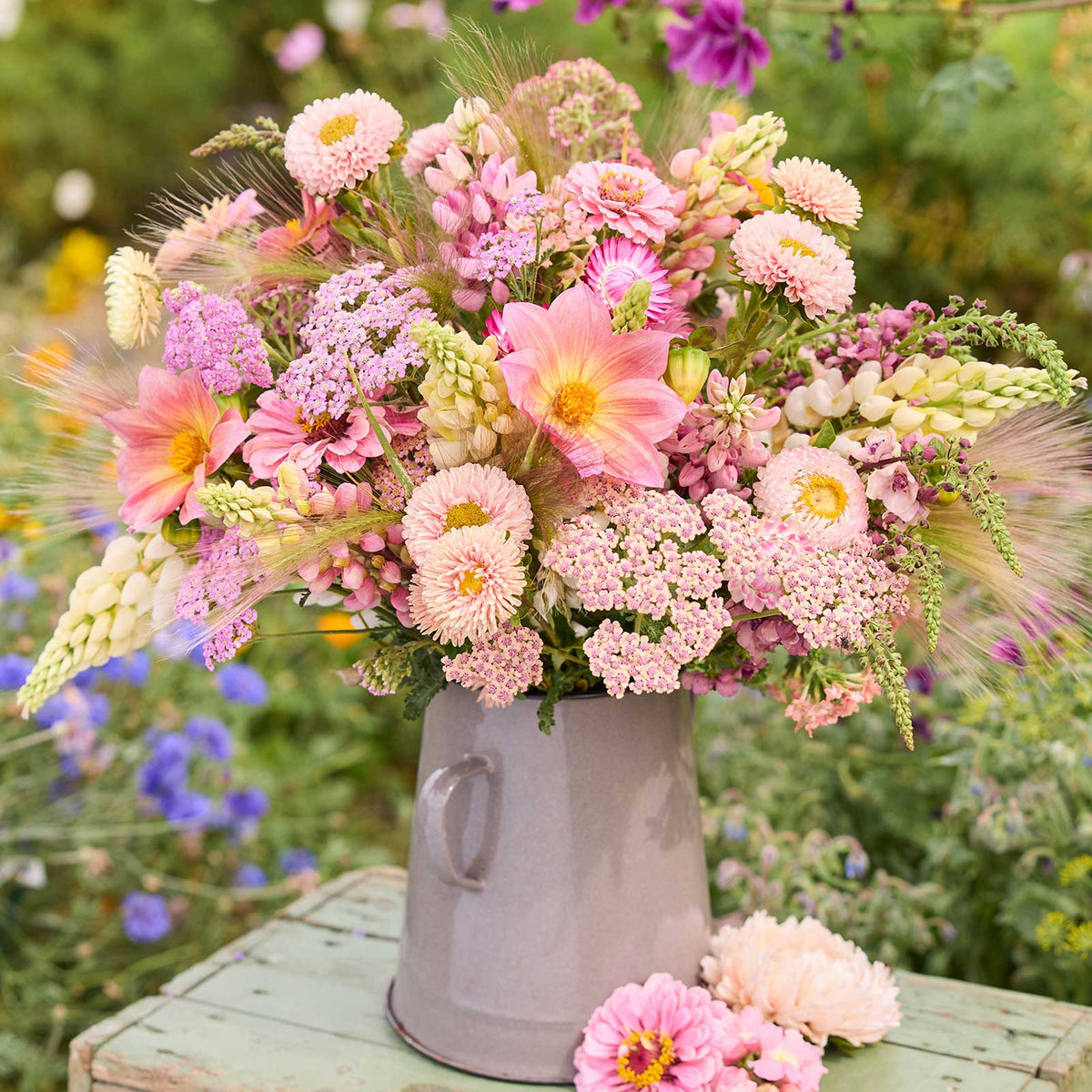 Bouquet of pink and white flowers from the pink prairie bouquet in a gray vase with a garden background