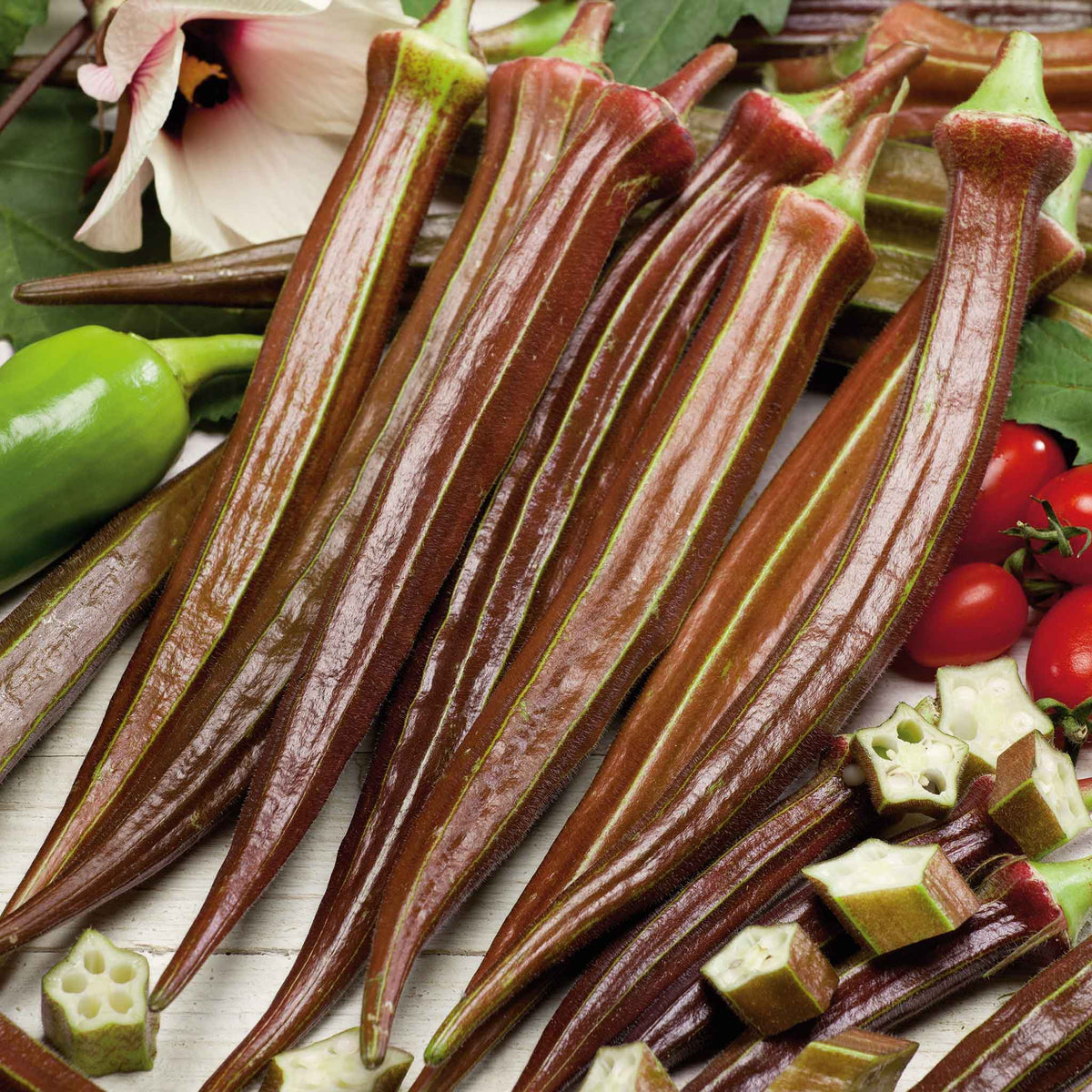 Several elongated Red Burgundy okra showing its deep red skin and green stems.