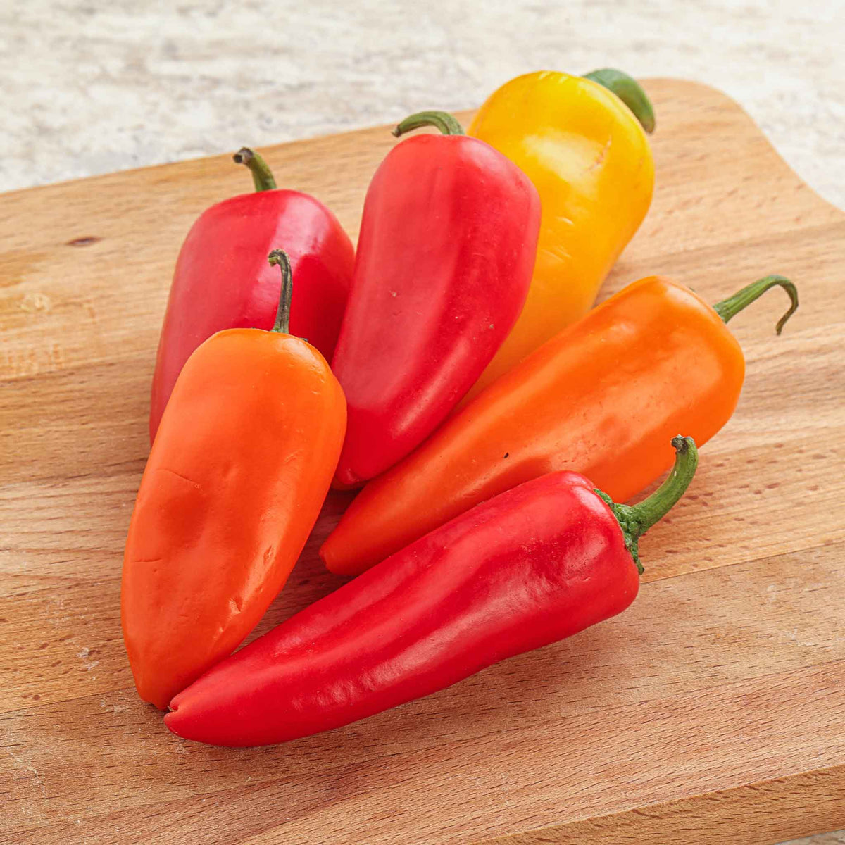 Bright orange and red Santa Fe Grande peppers, showcasing their smooth skin and vibrant color.